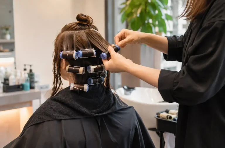 Coiffeuse enroulant des cheveux autour de bigoudis pour une permanente